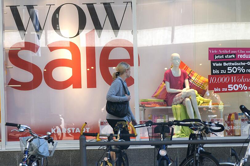 Schlussverkauf &ndash; unübersehbar: Eine Münchnerin schlendert an einem Schaufenster in der Innenstadt vorbei.