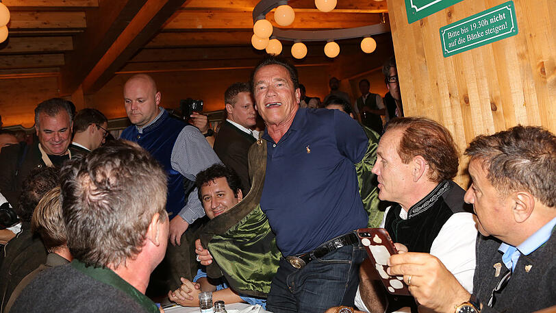 Erst eine kühle Maß, danach Dirigieren auf der Bühne: Die Bilder vom Schwarzenegger-Besuch im Schützen-Festzelt.