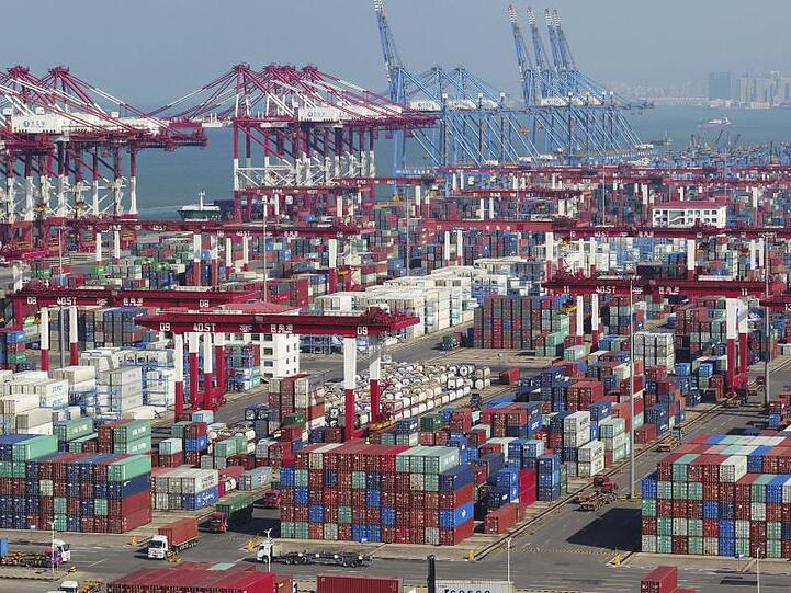 In einem Hafen stehen Container und Containerbrücken. Der Handelskrieg mit den USA setzt Chinas Wirtschaft kräftig zu.
