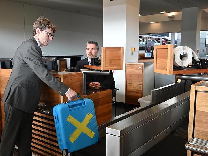 Engelbert Lütke-Daldrup, Vorsitzender der Geschäftsführung der Flughafen Berlin Brandenburg GmbH, gibt zum Probebetrieb einen Koffer auf.