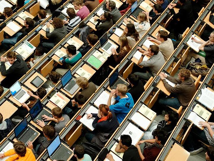 Studierende sitzen in einem großen Hörsaal einer Universität. Foto: Peter Kneffel/Archivbild