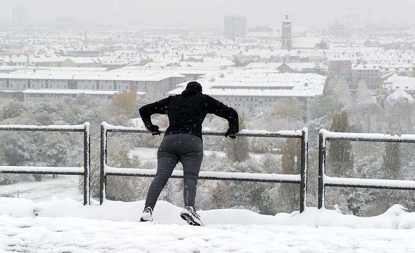 Liegestütze vor Neuhausen-Panorama: Eine Münchner Joggerin beim Frühsport im Schnee.