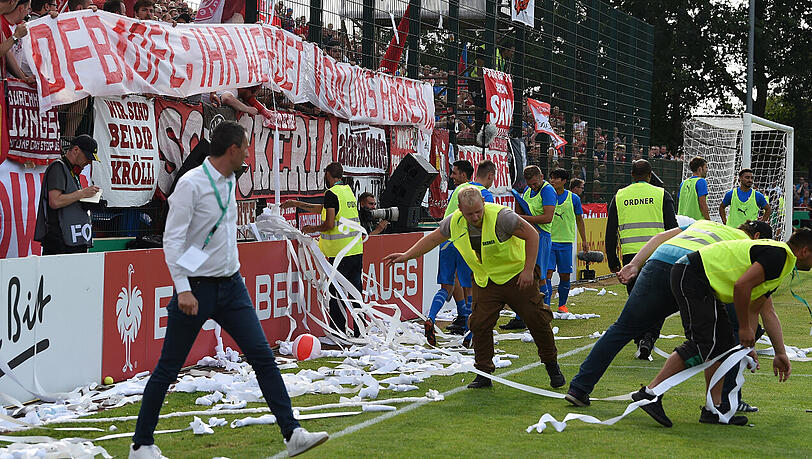 "Fans" des FC Bayern sorgen im Kehdinger Stadion für eine fünfminütige Unterbrechung, indem sie Plastikbälle und Toilettenpapierrollen auf den Rasen werfen.