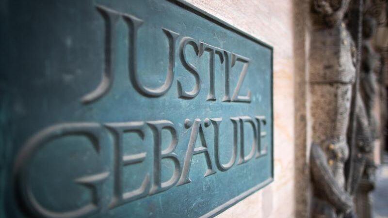 Ein Schild mit der Aufschrift "Justizgebäude" hängt am Eingang am Landgericht Nürnberg-Fürth. Foto: Daniel Karmann/dpa/Archivbild