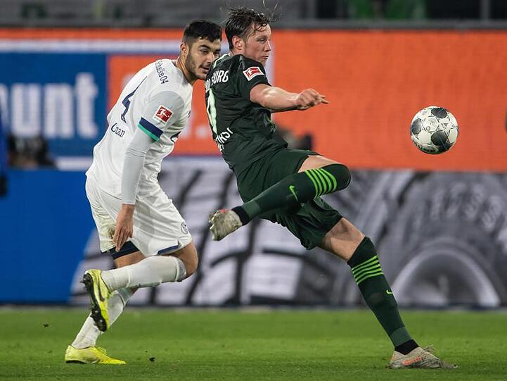 Wolfsburgs Wout Weghorst (r) zieht ab, Schalkes Ozan Kabak hat das Nachsehen.