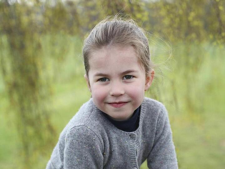 Die britische Prinzessin Charlotte auf einem Zaun im Garten.