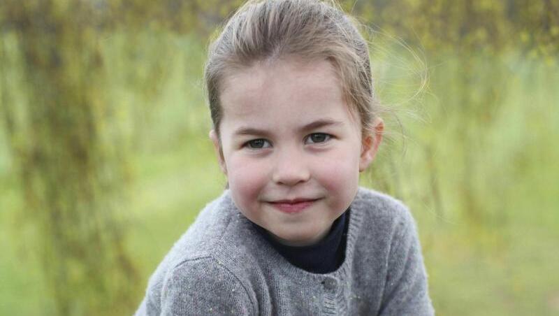 Die britische Prinzessin Charlotte auf einem Zaun im Garten. Die britische Prinzessin Charlotte auf einem Zaun im Garten.