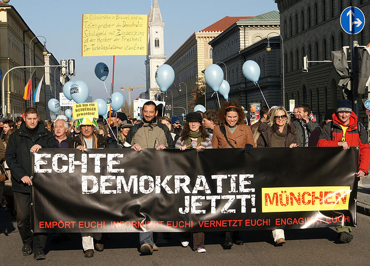 Mit Plakaten gingen rund 300 Menschen in München auf die Straße: Ihr Ziel: mehr Demokratie.