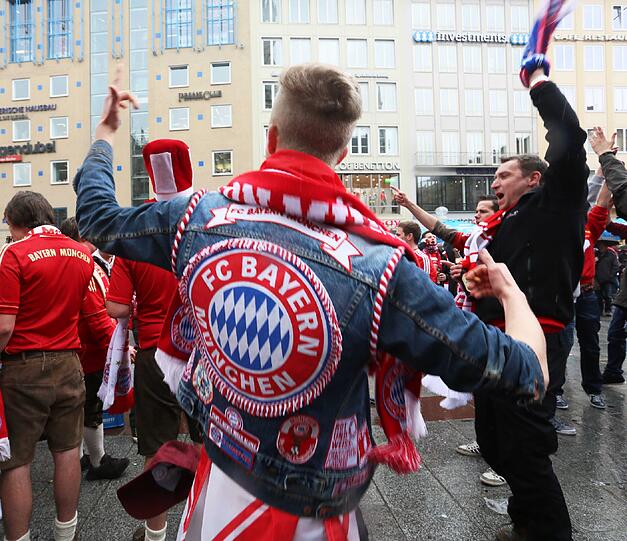 Die Bayernfans sind bereit für einen außergewöhnlichen Fußballabend. Bei brittischem Wetter und bayerischem Bier präsentieren sie die Fans lautstark am Marienplatz. Die besten Bilder.