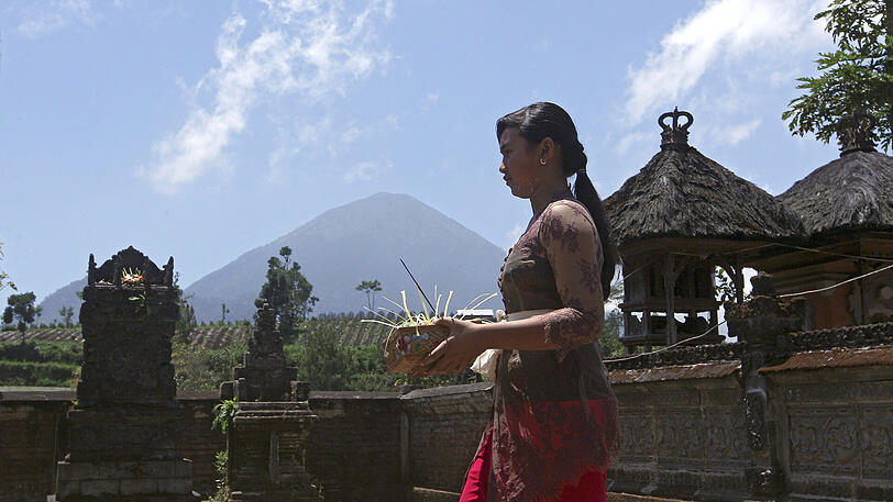 Ein Balinesin bringt Opfergaben in einen Tempel der 10 Kilometer vom Vulkan Mount Agung entfernt liegt.
