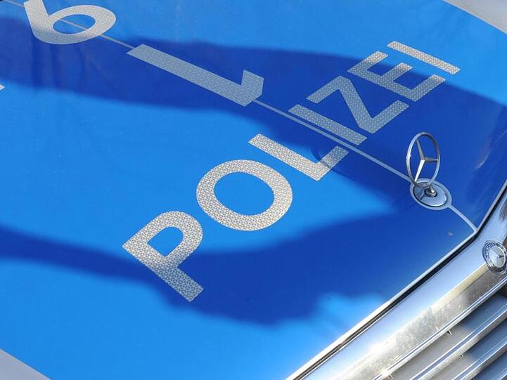 Der Schatten eines Polizisten fällt auf ein Polizeiauto. Foto: Franziska Kraufmann/Archiv