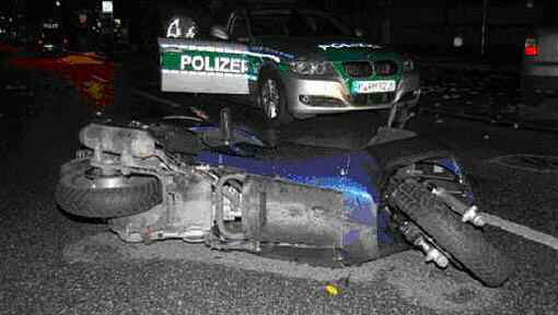 Das kaputte Motorrad liegt vor dem Polizeiauto. Das kaputte Motorrad liegt vor dem Polizeiauto.