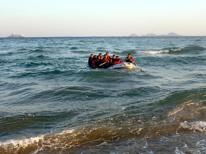 Migranten steuern in einem Schlauchboot auf die griechische Insel Kos zu. Die EKD will mit einem eigenen Schiff zur Seenotrettung im Mittelmeer aufbrechen.