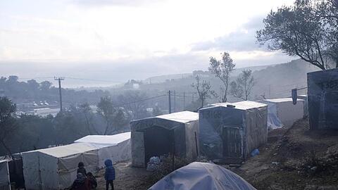 Kinder stehen nach einem Regenguss vor provisorisch errichteten Zelten außerhalb des Flüchtlingslagers Moria auf Lesbos. In und um die Registrierungslager harren mehr als 42.000 Menschen aus.