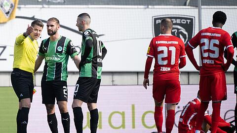Schiedsrichter Patrick Ittrich (l) spricht mit Fürths Simon Asta (2.v.l.), der gerade eine Rote Karte bekommen hat.