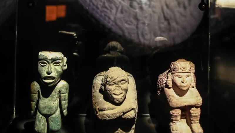 Eine Grünsteinfigur mit Kalenderzeichen (l-r), der bucklige Gott Nanahuatzin und der Sonnengott Tonatiuh. Eine Grünsteinfigur mit Kalenderzeichen (l-r), der bucklige Gott Nanahuatzin und der Sonnengott Tonatiuh.