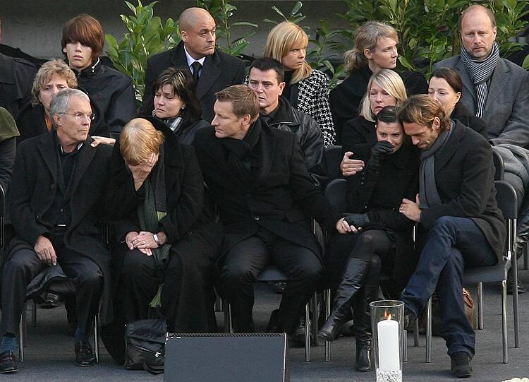 Teresa Enke wird von Marco Villa (r.), einem Freund der Familie, getröstet. Links die Eltern von Robert Enke, in der Mitte der frühere Berater des Verstorbenen, Jörg Neblung.