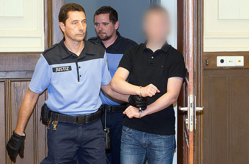 Der Angeklagte wird in Handschellen von Justizbeamten in den Gerichtssaal des Leipziger Landgerichts geführt.