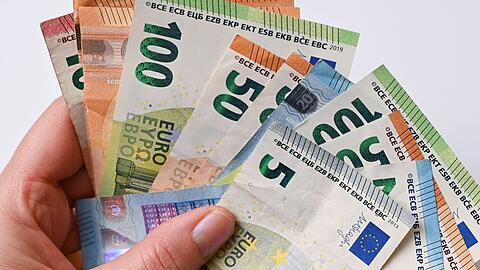 Eine Frau hält Geldscheine in der Hand (Symbolbild)