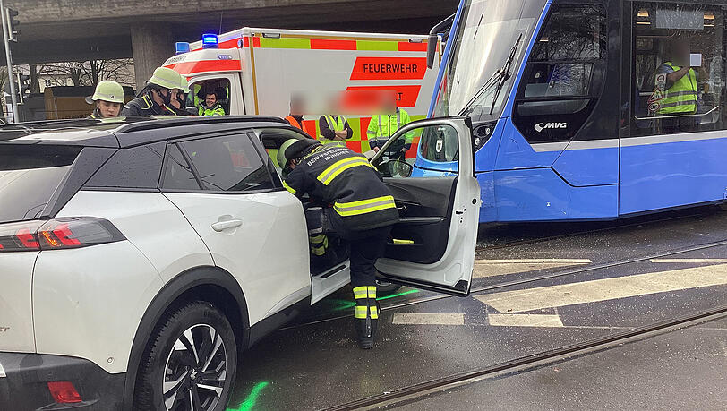 Ein Feuerwehrmann k&uuml;mmer sich an der Unfallstelle um den Fahrer des Autos.