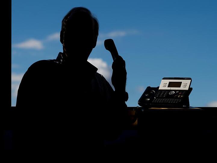 Ein Mann hält einen Telefonhörer. Foto: Julian Stratenschulte/dpa/Symbolbild