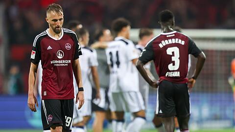 Die Nürnberger Florian Hübner (l) und Sadik Fofana (r) stehen nach dem Abpfiff auf dem Rasen.