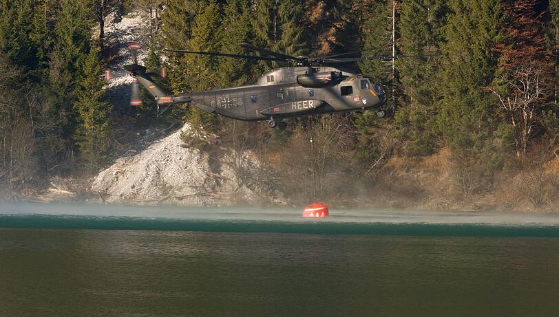 Die vier eingestzen Hubschrauber fliegen über den Sylvenstein-Stausee...