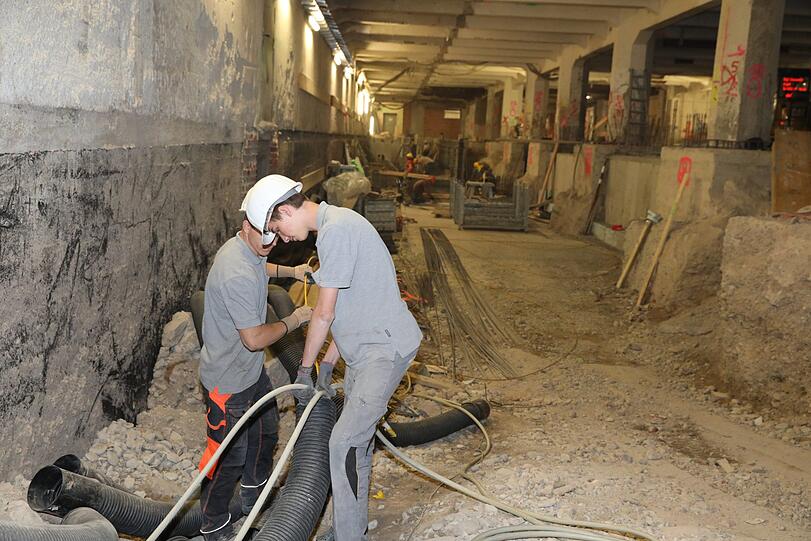 Hier werkeln die Bauleute rund um die Leitungen im Keller.