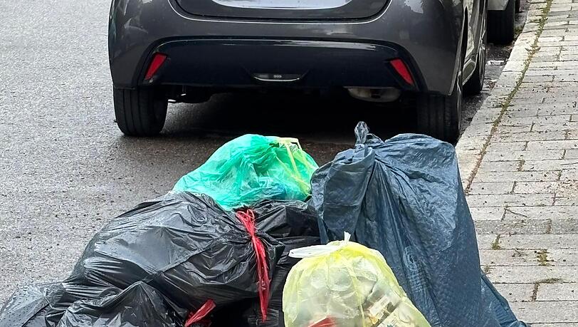 Weil die M&uuml;llabfuhr nicht durch die Stra&szlig;e fahren kann, bleibt der M&uuml;ll auf der Stra&szlig;e liegen.