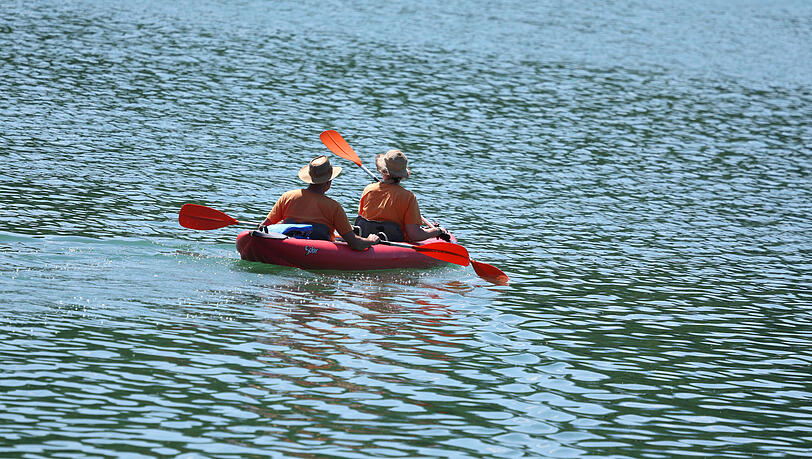 Ausflügler im Kanu paddeln auf dem Wasser des Illasbergsees. Ausflügler im Kanu paddeln auf dem Wasser des Illasbergsees.