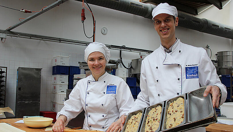 Produktionsleiterin Heike Grosch zeigt, wie der Stollen mit einem französischen Rollholz seine typische Hauben-Form erhält. Magnus Müller-Rischart hat schon die Backform parat. Produktionsleiterin Heike Grosch zeigt, wie der Stollen mit einem französischen Rollholz seine typische Hauben-Form erhält. Magnus Müller-Rischart hat schon die Backform parat.