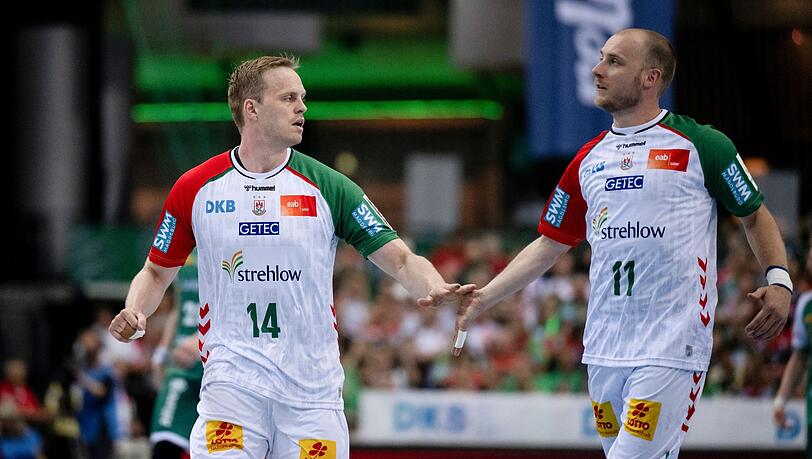 Magdeburgs Omar Ingi Magnusson (l) und Daniel Pettersson schlagen nach einem Tor ab.
