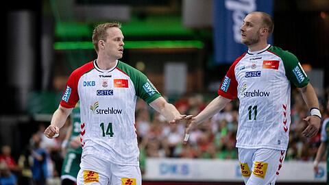 Magdeburgs Omar Ingi Magnusson (l) und Daniel Pettersson schlagen nach einem Tor ab.
