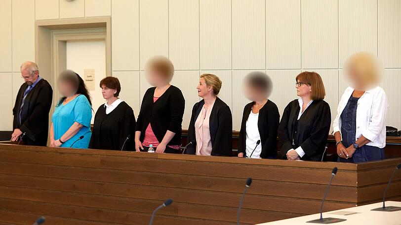 Die vier angeklagten ehemaligen Erzieherinnen der Kita Antweiler und ihre Anwälte, (l-r) Claudia W., Anna N., Sarah B. und Gisela N. stehen im Gerichtssal im Landgericht beim Prozess wegen mutmaßlicher Misshandlungen.