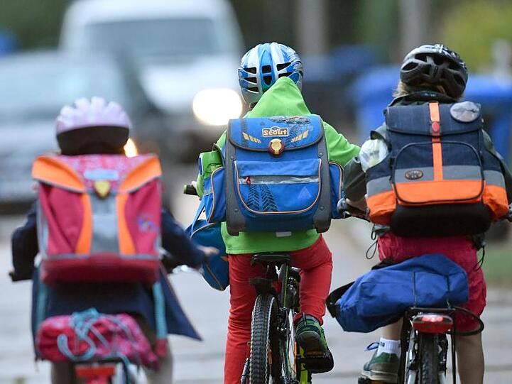Kinder sind mit dem Fahrrad unterwegs zur Schule.
