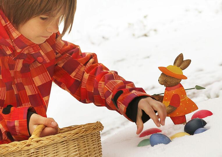 Die zehnjährige Lea sammelt am Ostersonntag (08.04.2012) in Baierbrunn im Landkreis München (Oberbayern) bemalte Ostereier aus dem Schnee.