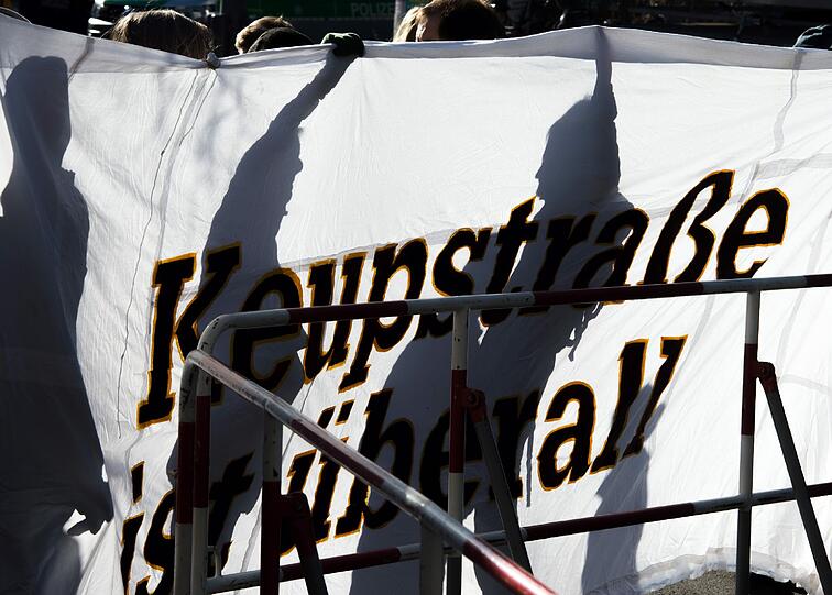 Demonstranten und Gegendemonstranten stehen vor der Polizeiabsperrung in der Nymphenburgerstraße.