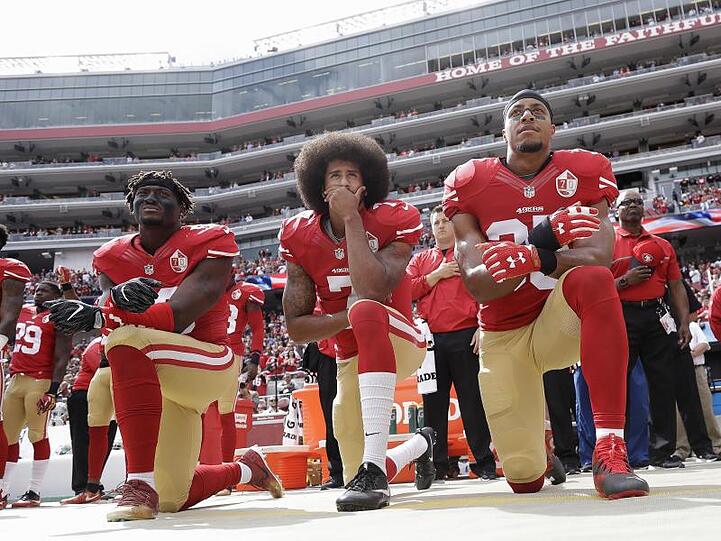 Gegen Rassismus und Polizeigewalt: Colin Kaepernick (M) kniet mit Teamkollegen während der Nationalhymne vor einem NFL-Spiel.