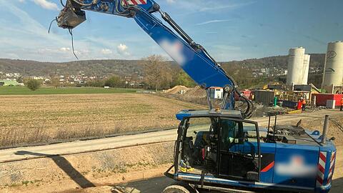 Der besch&auml;digte Bagger steht an einer Baustelle neben den Bahngleisen.