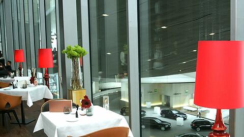 &bdquo;EssZimmer&ldquo; mit Blick auf die Garage: In der BMW-Welt hat ein Restaurant eröffnet, das in Münchens Spitzenliga aufsteigen soll.