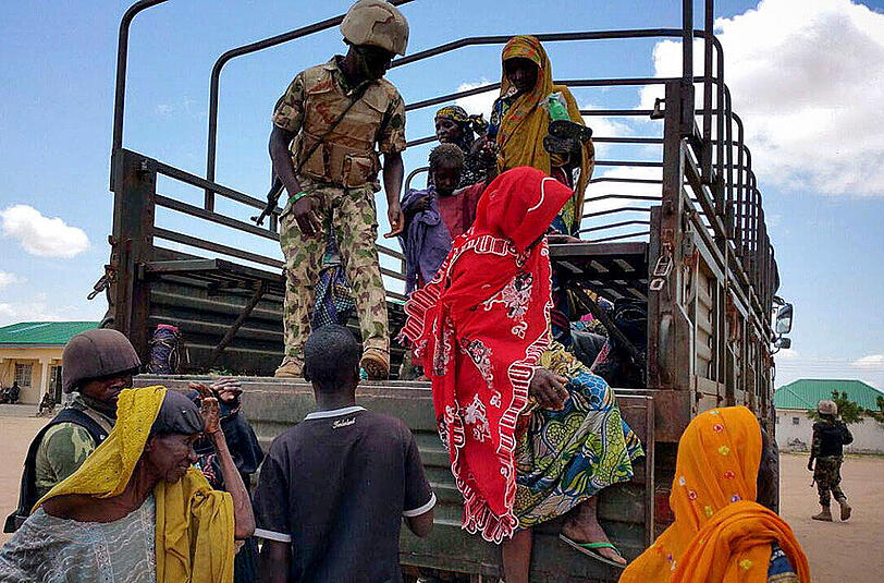 Im Bundestaat Borno steigen befreite Boko-Haram-Geiseln von einem Fahrzeug der nigerianischen Armee.
