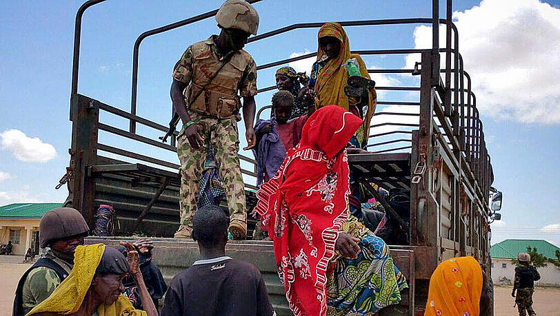 Im Bundestaat Borno steigen befreite Boko-Haram-Geiseln von einem Fahrzeug der nigerianischen Armee. Im Bundestaat Borno steigen befreite Boko-Haram-Geiseln von einem Fahrzeug der nigerianischen Armee.