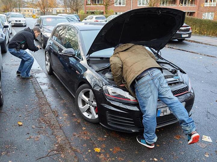 Unter der Haube: Die Kontrollgruppe "Autoposer" überprüft einen aufgemotzten Golf GTI.
