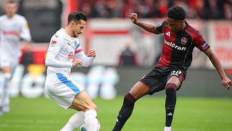 Kiel-Kapitän Steven Skrzybski (links) und Pape Demba Diop von Nürnberg kämpfen um den Ball.