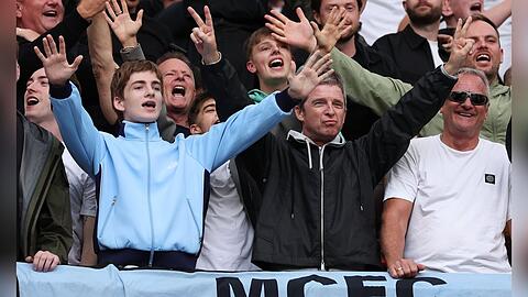 Noel Gallagher (2.v.re., schwarze Jacke) mit seinen beiden S&ouml;hnen Sonny (li., blaue Jacke) und Donovan (Mitte, verdeckt, wei&szlig;es T-Shirt) im Stadion von Manchester City.