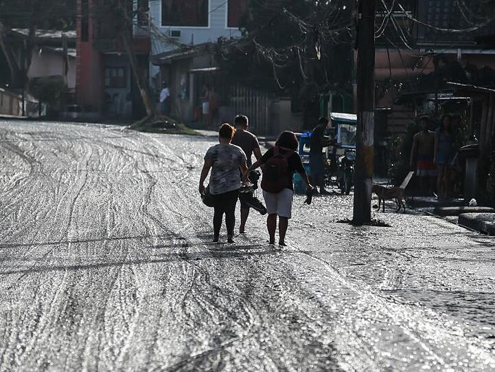 Eine Straße auf der philippinischen Hauptinsel Luzon ist von Asche bedeckt.