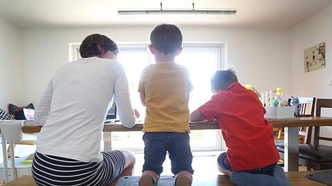 Eine Mutter betreut ihre Kinder, deren Kita infolge der Corona-Pandemie geschlossen ist.