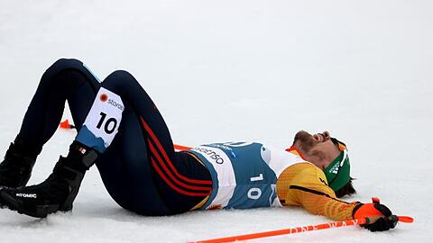 Fabian Rießle aus Deutschland liegt erschöpft im Ziel.