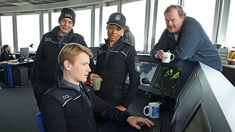 "Der Bremerhaven-Krimi. Geschäft mit dem Tod": Zöllner Sven-Erik Dröse (Lukas Zumbrock, sitzend) hat eine heiße Spur (v.l.n.r. Elena Uhlig, Cynthia Micas, Bernd Hölscher).