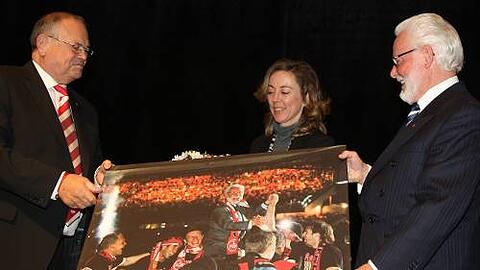 FCN-Präsident Franz Schäfer (l.) überreicht Michael A. Roth und Ehefrau Angie als Geschenk ein Bild von Roths größtem sportlichen Erfolg mit dem Club, dem Pokalsieg.